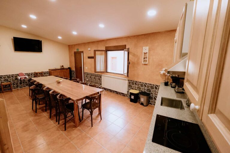 Cocina comedor amplia con mesa para 20 comensales en casa rural en Burgos.